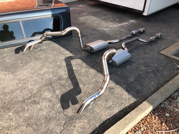 Set of polished metal exhaust pipes on a concrete surface