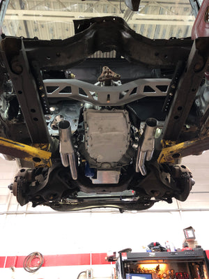 Car chassis on a lift in a garage setting