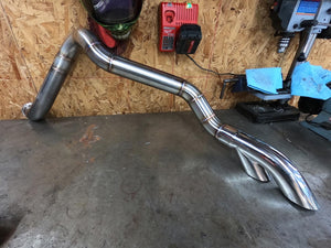 Metallic exhaust system on a concrete floor with a workshop background
