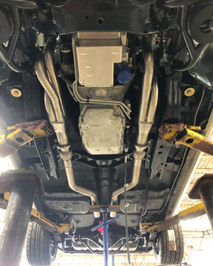 Undercarriage of a vehicle with visible suspension components and exhaust system.