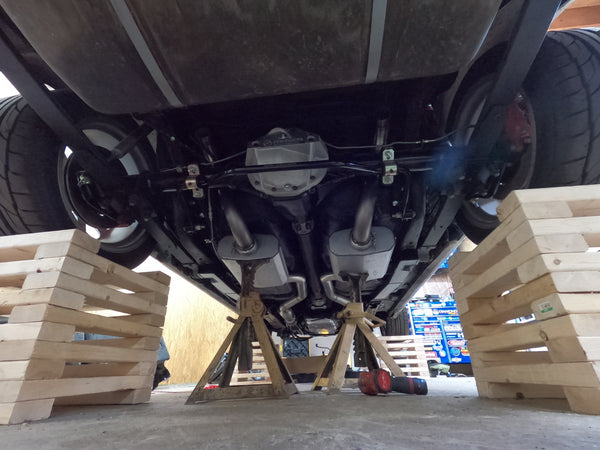 Undercarriage of a vehicle on wooden stands with a blurred background