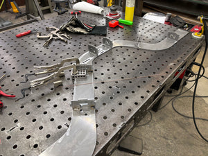 Metalworking bench with metal components and tools on a workshop floor