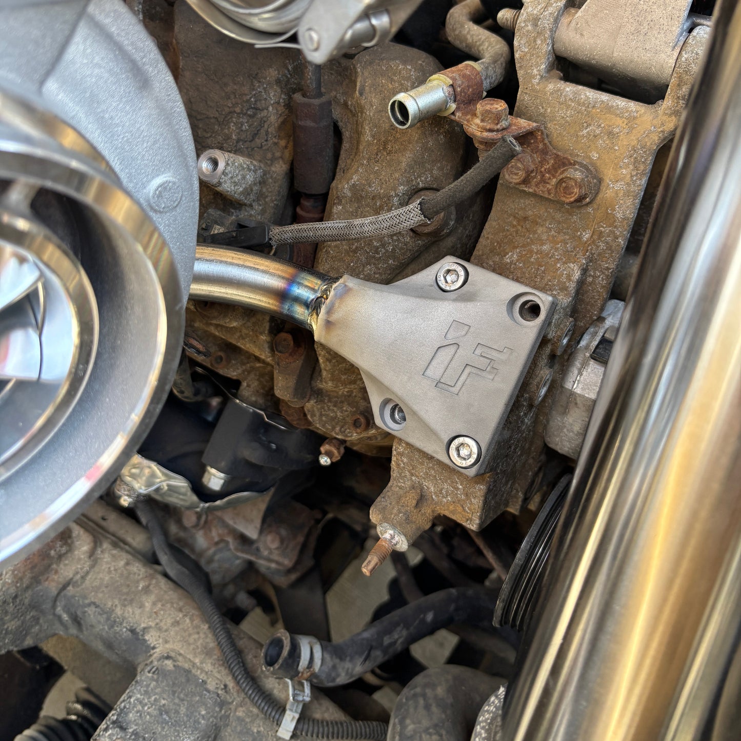 Close-up of a mechanical component under a vehicle, likely part of an engine or transmission system.