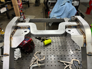 Metal frame on a workbench with tools in a workshop setting