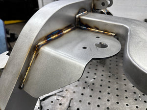 Detail shot of welded chassis assembly sitting on frame table.