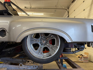 Car wheel on a lift in a garage setting