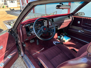 Car interior with a steering wheel and dashboard, showing signs of wear.