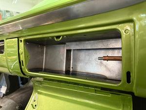 Close-up of a green metal component with a cylindrical object inside, possibly a machine or vehicle part.