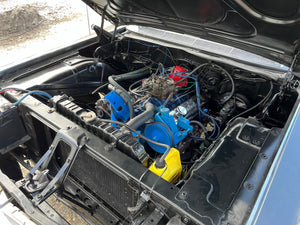 Car engine with visible components and a blue pulley system.