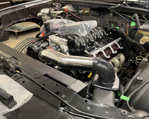 Car engine with visible components in a workshop setting