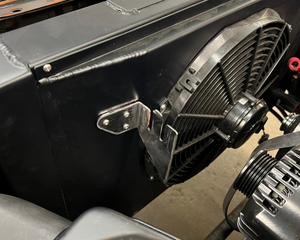 Close-up of a vehicle's front bumper and grille with tools in the background.