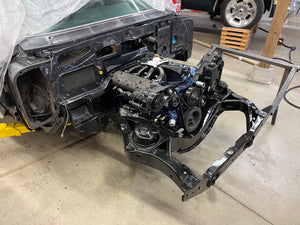 Car engine and chassis on a concrete floor in a workshop