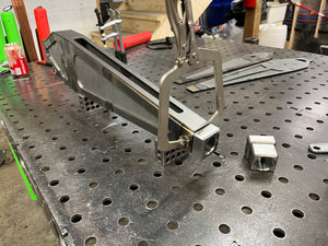 Metalworking setup on a metal workbench with tools and materials.