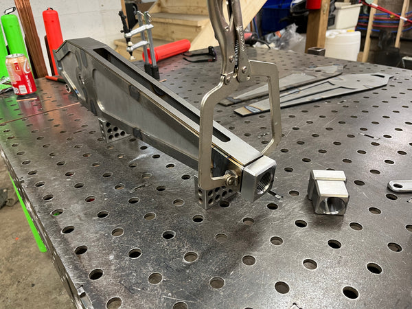 Metalworking setup on a metal workbench with tools and materials.