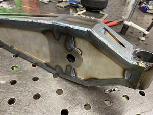 Metal component on a workbench with tools in the background