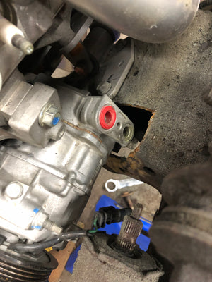 Close-up of a mechanical component with a red mark on a vehicle.