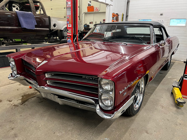 Vintage red Pontiac car in a garage setting