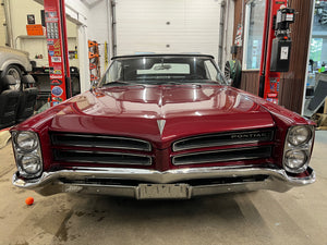 Vintage red Pontiac car in a garage setting
