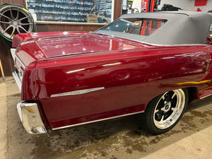 Red classic Pontiac with chrome details in a showroom setting