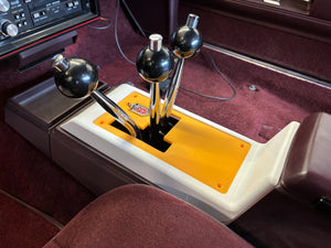 Close-up of a car gear shift lever with a yellow cover inside a vehicle.