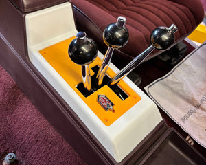 Close-up of a vintage car interior with a dashboard ornament and a map.