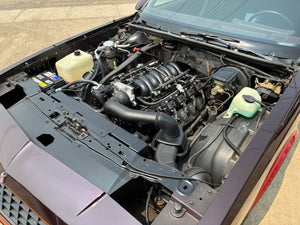 Car engine compartment with various components visible