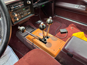 Vintage car interior with dashboard and ceiling lights.