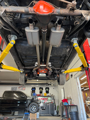 Car undercarriage inspection with a funnel on a lift in a garage.