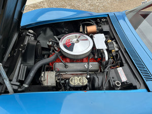 Engine compartment of a blue car with visible components.