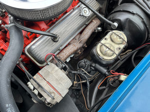 Close-up of a car engine with visible components and wiring.