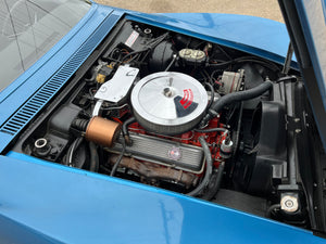 Engine compartment of a blue car with visible components