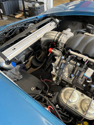 Close-up of a car with an LS3 engine with visible components and wiring.