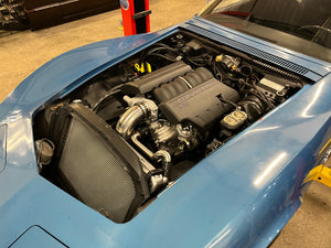 Engine compartment of a blue 1969 Corvette with visible LS3 engine components