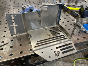 Metalworking setup with metal brackets on a workbench