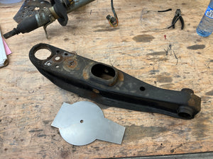 Mechanical component on a wooden workbench with tools and a water bottle in the background