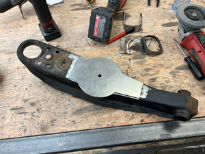 Mechanical part on a wooden workbench with tools in the background