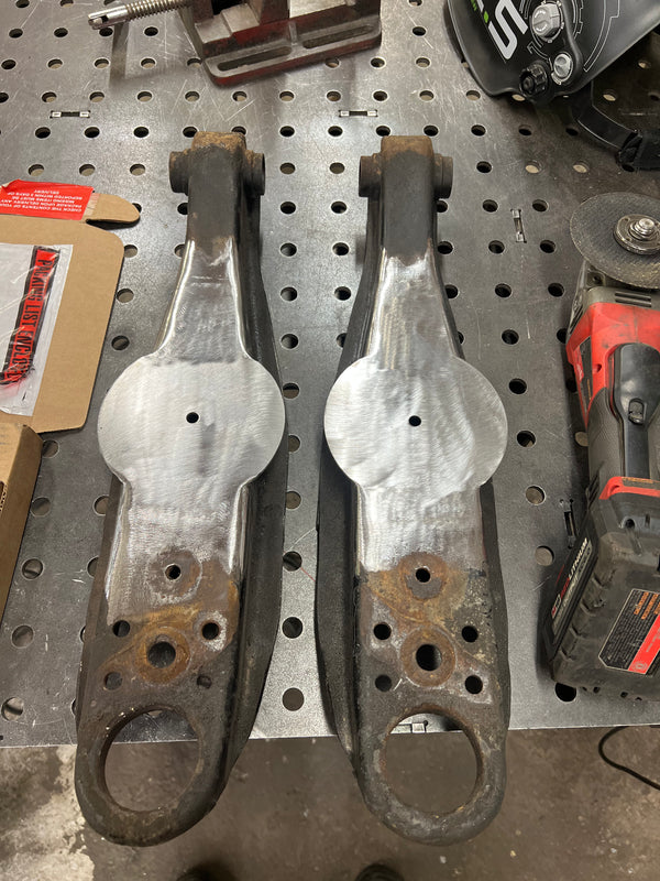 Two metal brackets on a pegboard with tools in the background