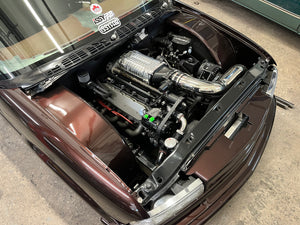 S10 engine compartment with visible components on a concrete floor.