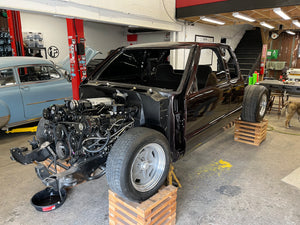 S10 in a garage with engine removed and parts on wooden pallets