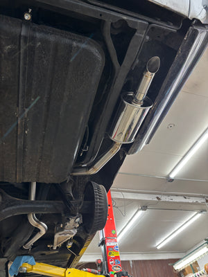 Close-up of a car exhaust system in a garage setting