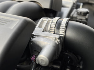 Close-up of a car alternator with visible branding on a vehicle engine.