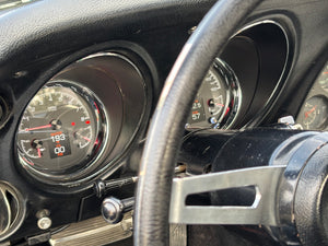 Close-up of a car dashboard with Dakota Digital gauges and steering wheel