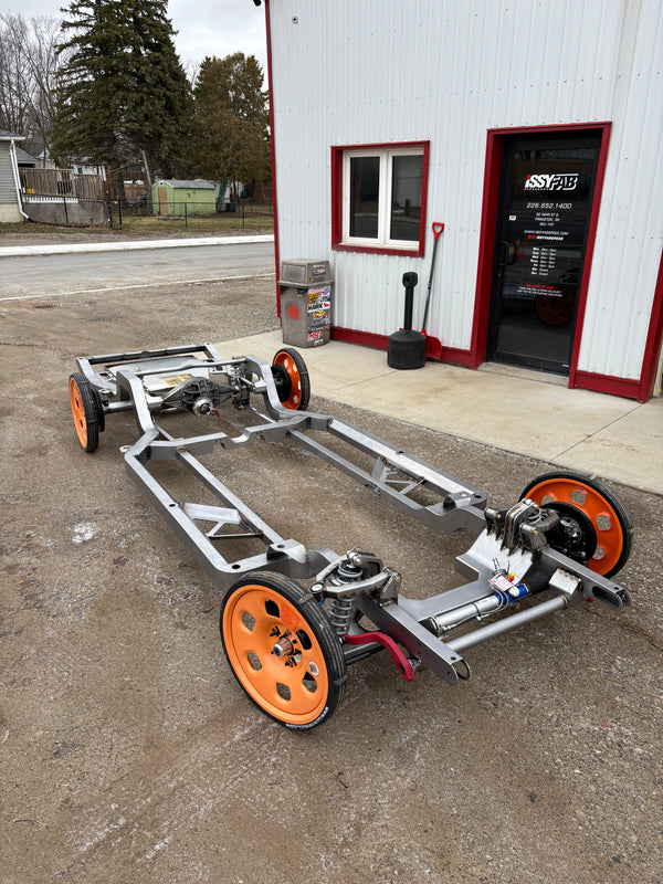 Metal frame with orange wheels on a concrete surface next to a building.