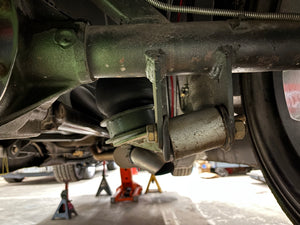 Close-up of a vehicle's undercarriage with mechanical components.