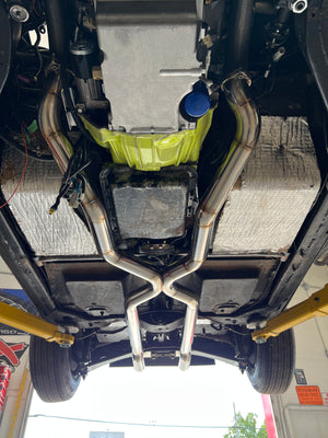 Close-up of a car's undercarriage with suspension components and a yellow oil filter.