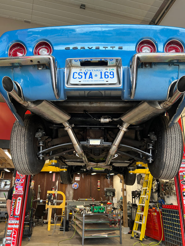Blue Corvette car on a lift in a garage with visible license plate