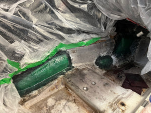 Close-up of a mechanical component with green tape on a plastic bag background