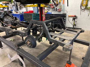 Metal frame structure in a workshop with tools and equipment in the background